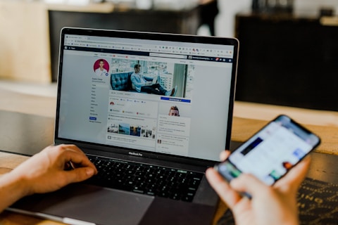 Laptop và điện thoại hiển thị bảng tin mạng xã hội
